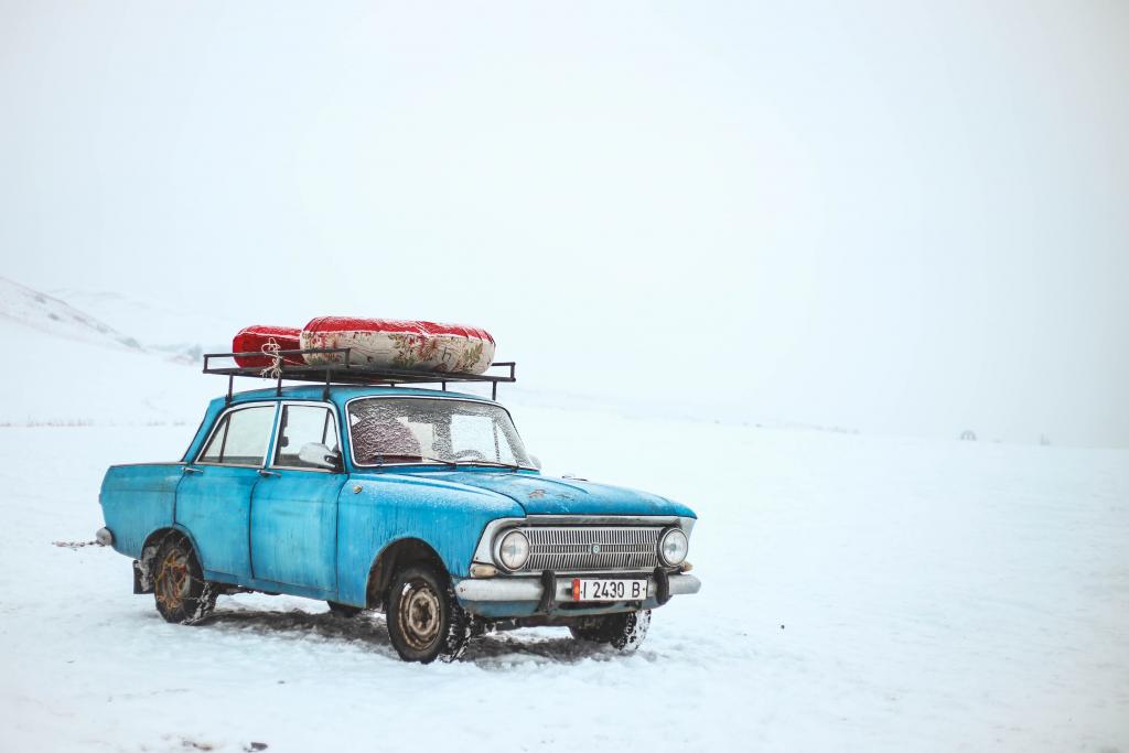 Das Auto ist auf einer Winterstraße mit einer Schutzhaube versehen. Schützt  das Fahrzeug vor Schnee und Eis Stockfotografie - Alamy